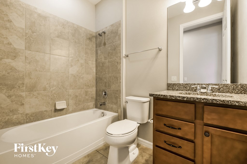 a bathroom with a toilet and a tub and a sink