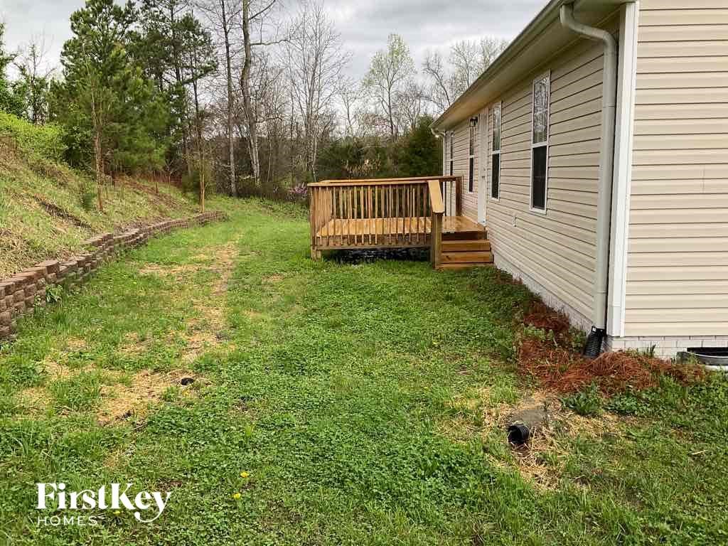 A small house with a porch and a grassy yard.