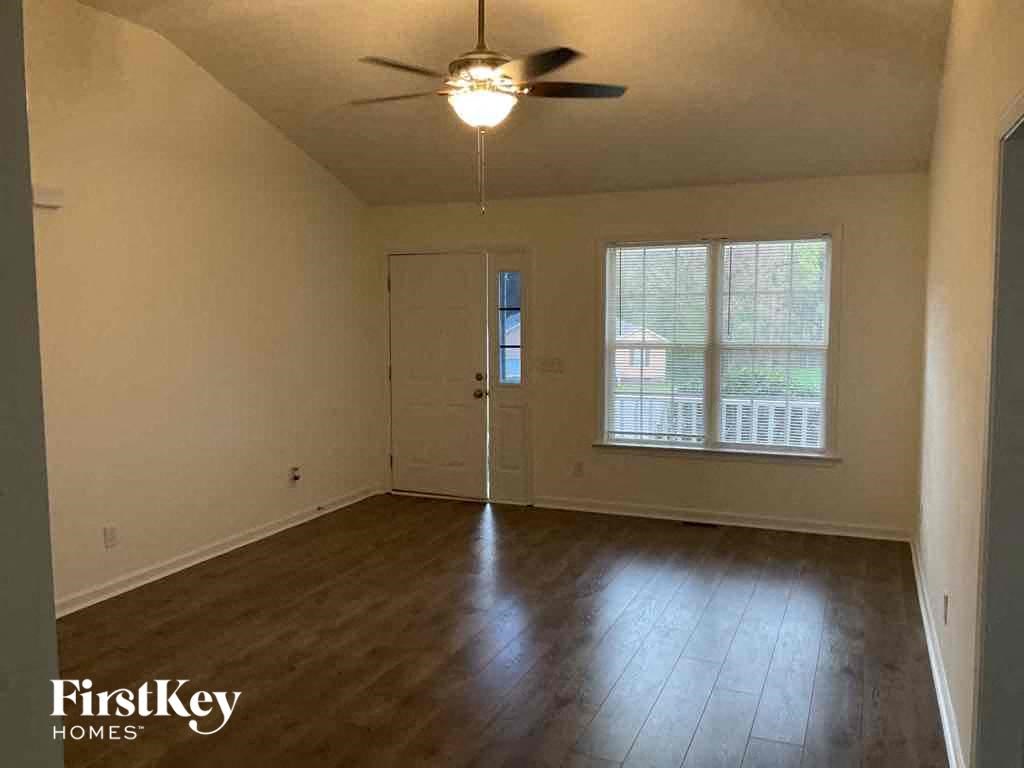A room with a ceiling fan and wooden flooring.