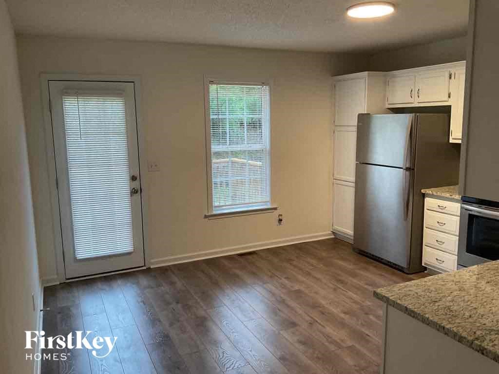A kitchen with a refrigerator, oven, and microwave.