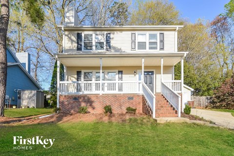 a white house with a white porch and a lawn