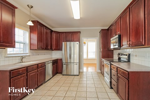 a kitchen with wooden cabinets and a stainless steel refrigerator