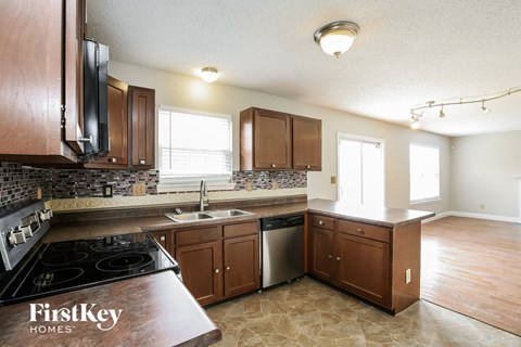 A kitchen with wooden cabinets and a black stove top oven.