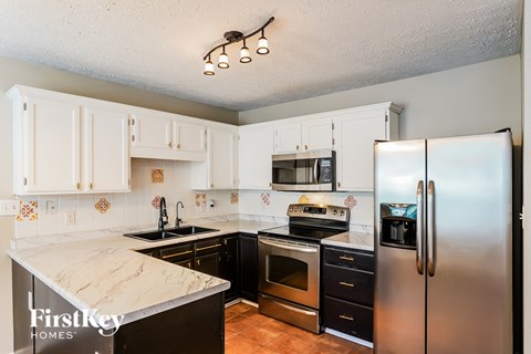 A kitchen with a refrigerator on the right side.