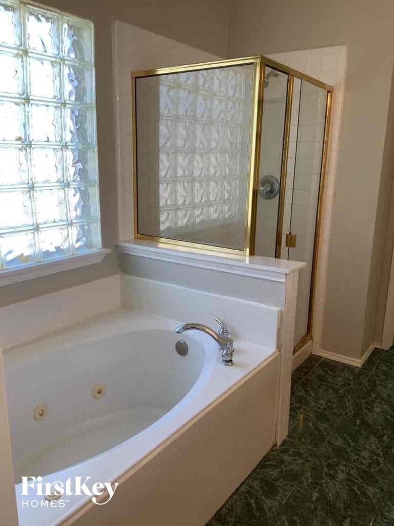 a bathroom with a bath tub and a mirror