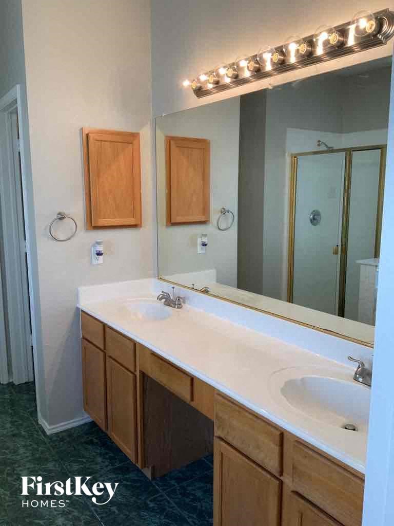 a bathroom with two sinks and a large mirror