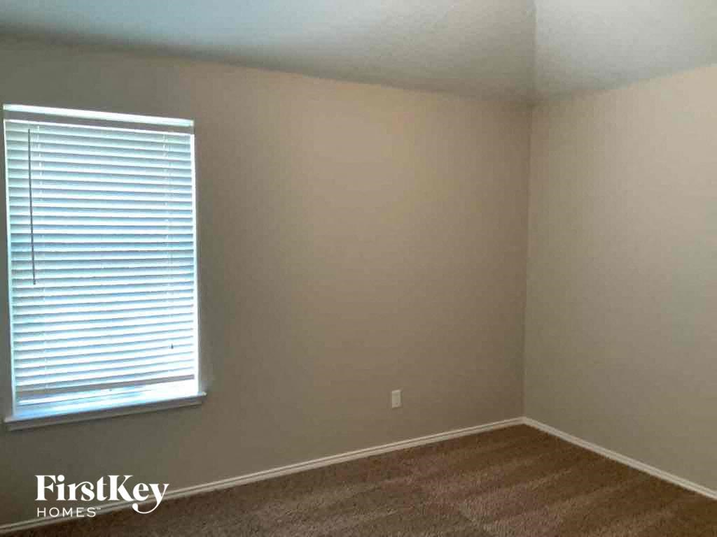 a room with a window and a brown carpet