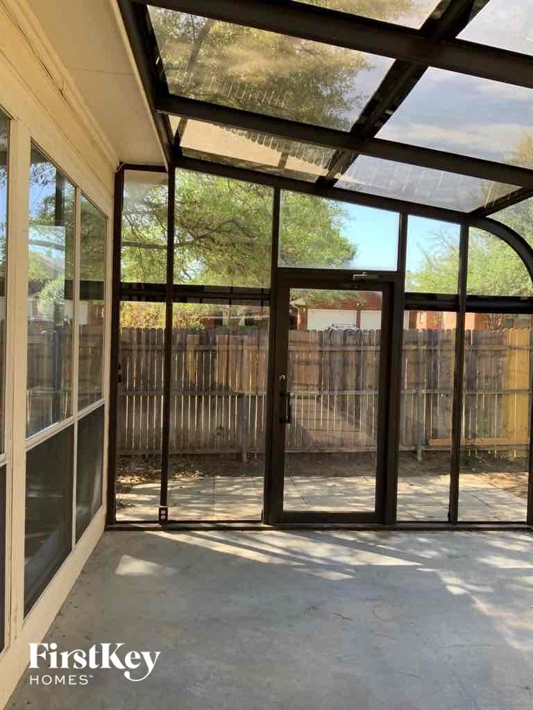 a patio area with glass doors and a fence