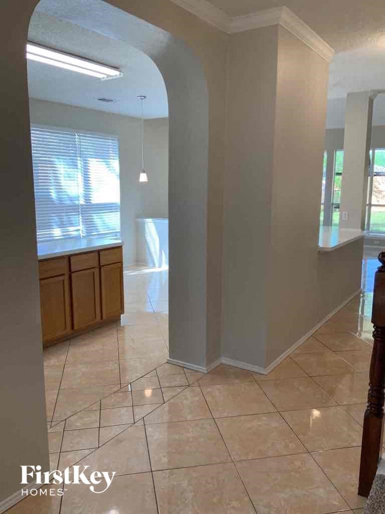 an empty kitchen and living room with tiled flooring