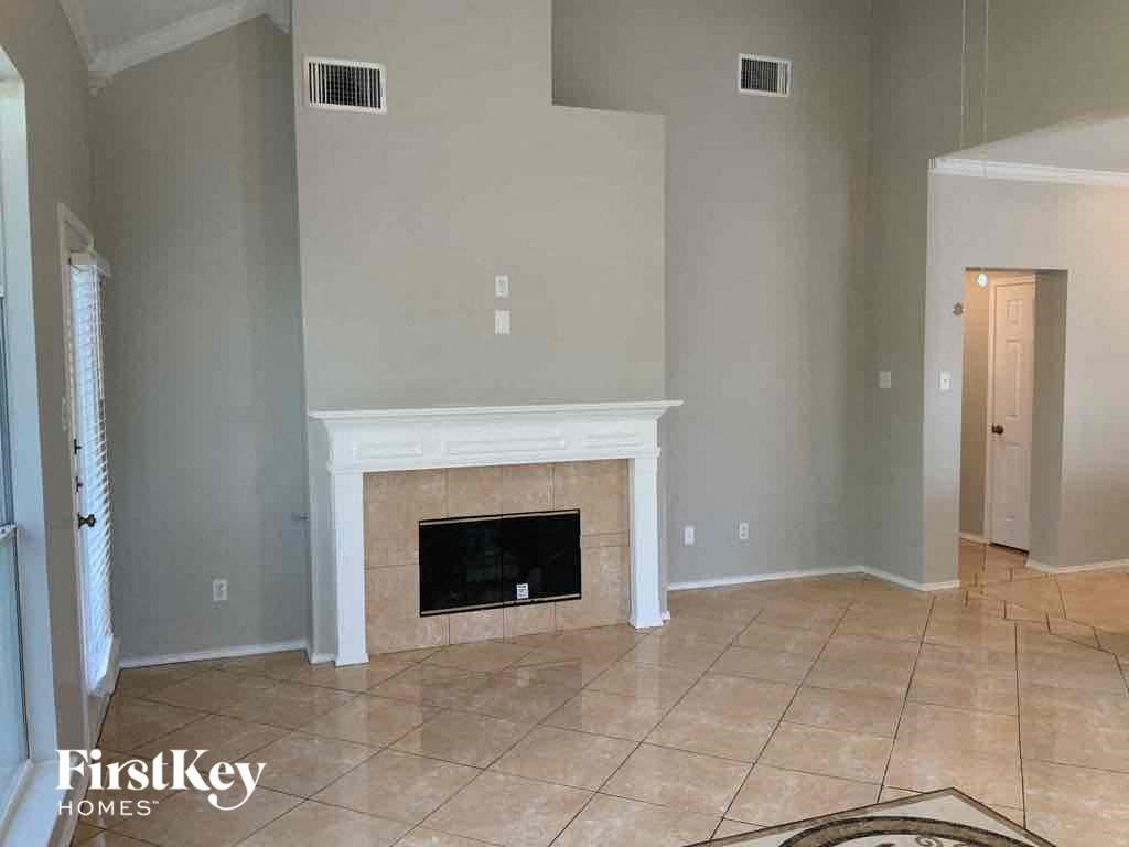 a living room with a fireplace and a tiled floor