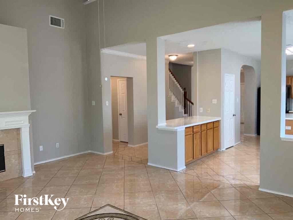 an empty living room with a fireplace and a staircase