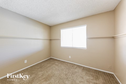 the living room of a home with carpet and a window