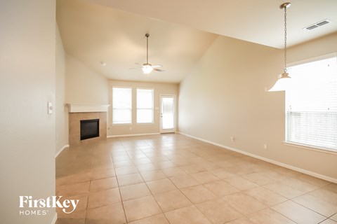 A spacious living room with a television and a fireplace.