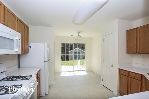 A kitchen with white appliances and wooden cabinets.