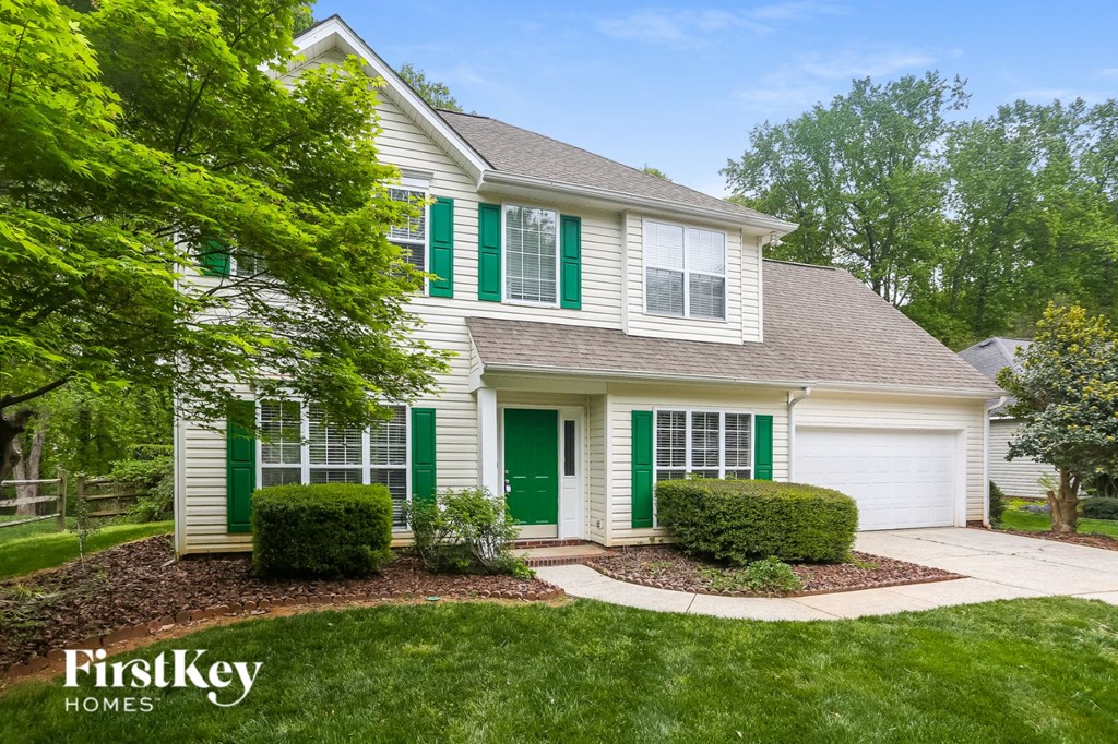 a white house with green shutters and a front yard