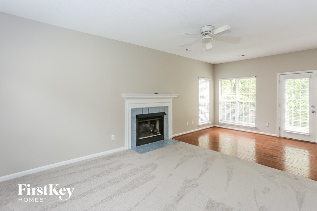 an empty living room with a fireplace and hardwood floors