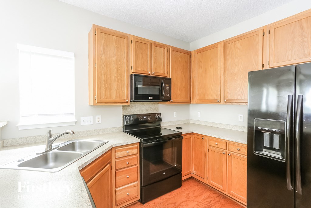 a kitchen with black appliances and wooden cabinets