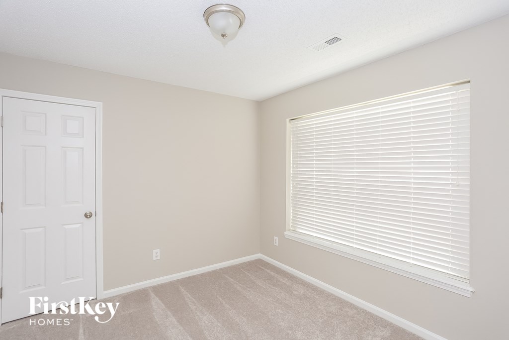 a bedroom with a large window and a white door
