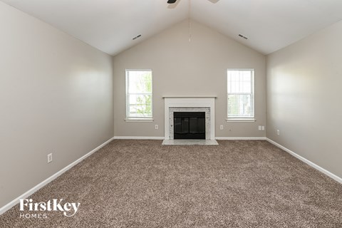 the living room has a fireplace and carpeted flooring
