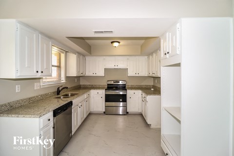 A kitchen with white cabinets and appliances.