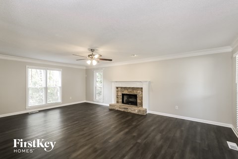 a living room with a fireplace and a ceiling fan