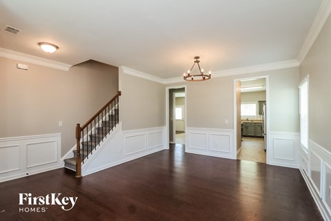 a living room with white wainscoting and a staircase