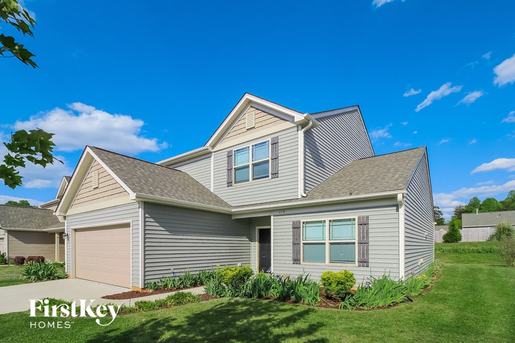 a gray house with a yard and a blue sky