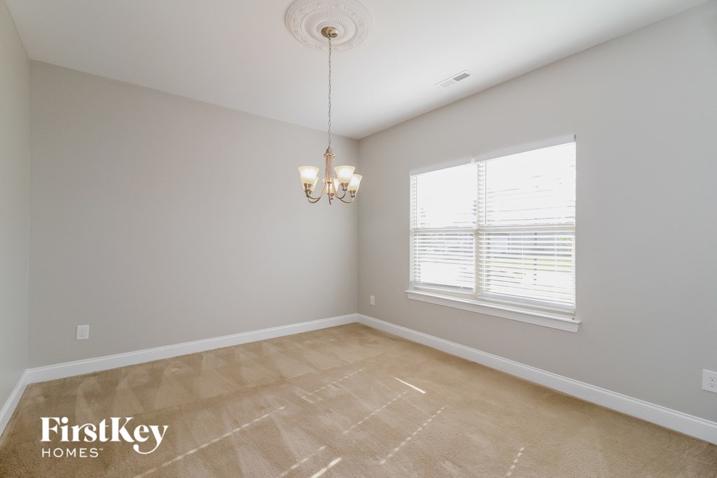 the living room of a home with a large window and a chandelier