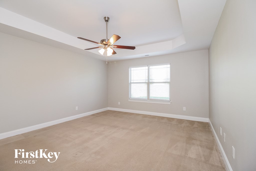 an empty room with a ceiling fan and a window