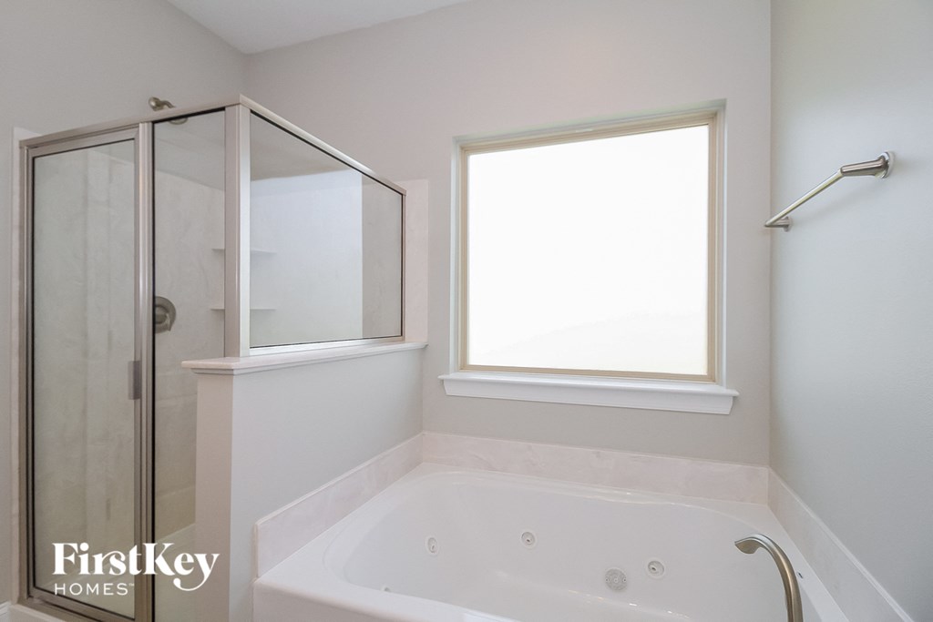 a small bathroom with a tub and a shower and a window