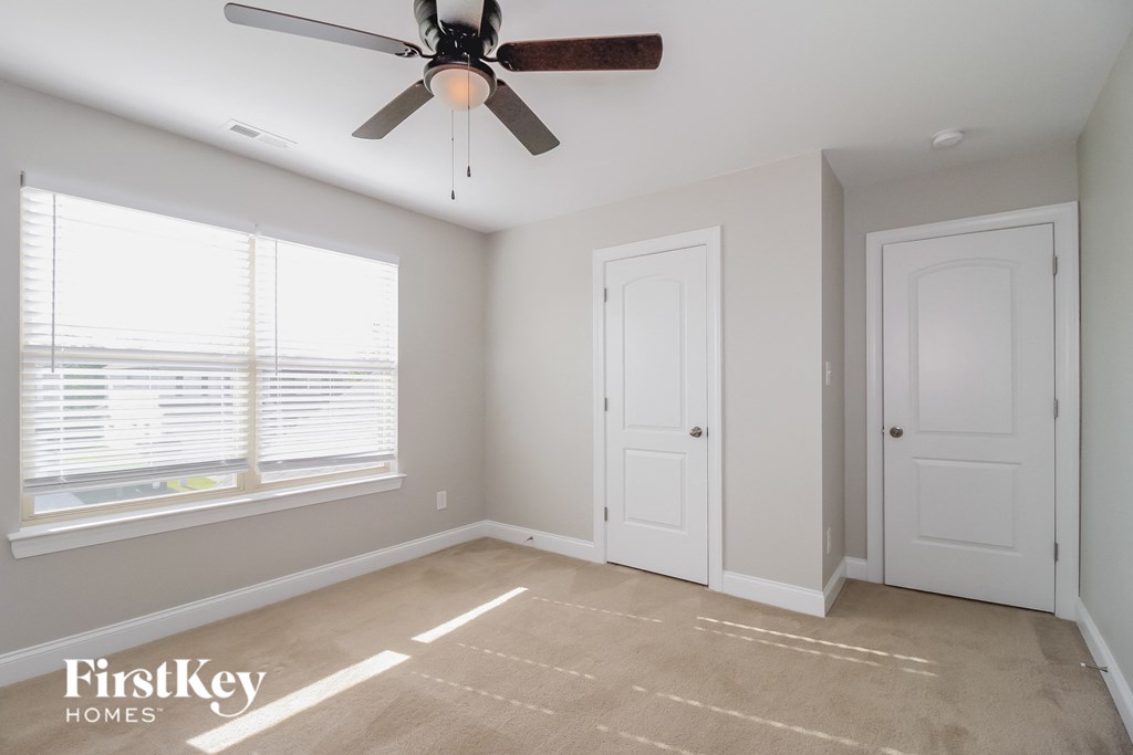 an empty room with a ceiling fan and a window