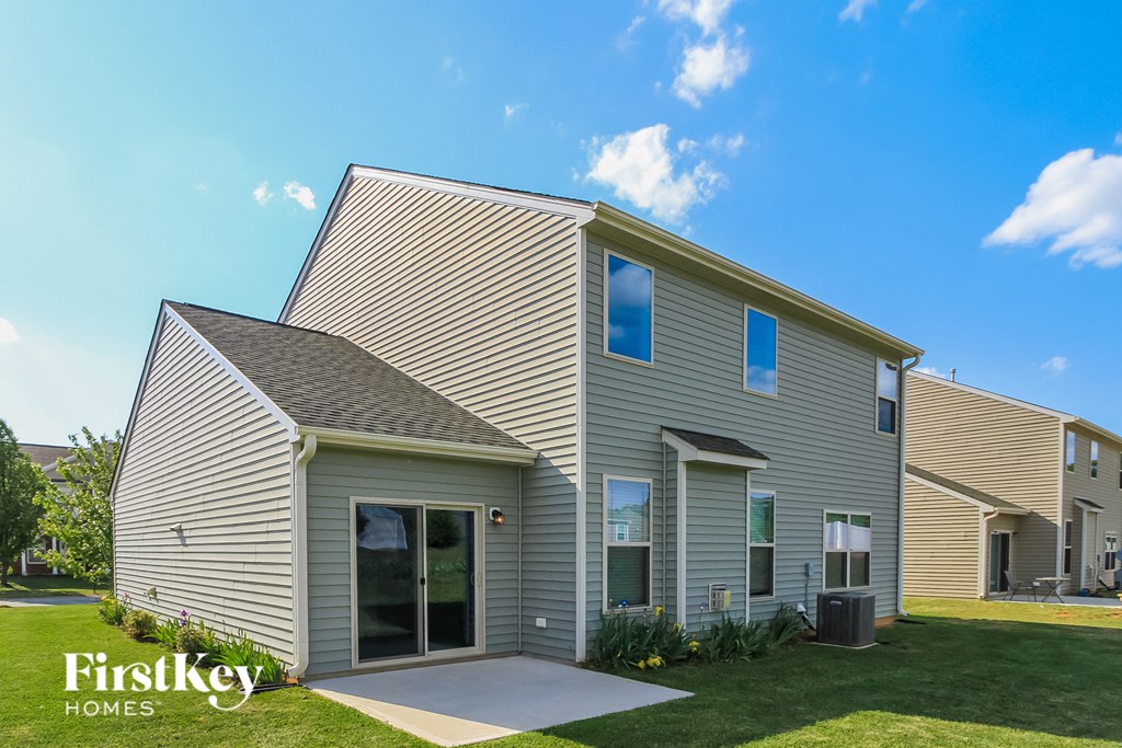 a gray house with a gray roof and a grassy yard