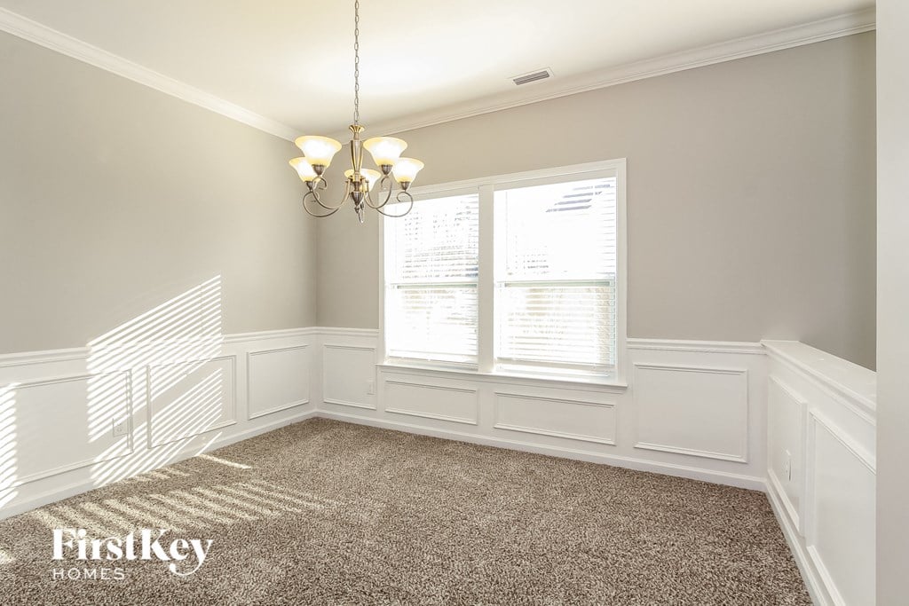 a dining room with a carpeted floor and two windows