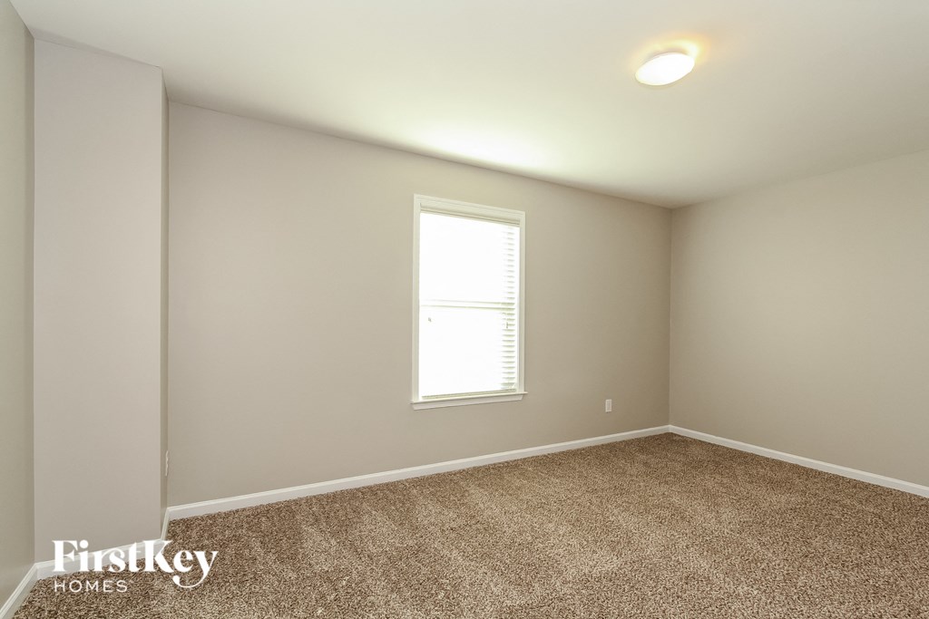 a bedroom with a carpeted floor and a window