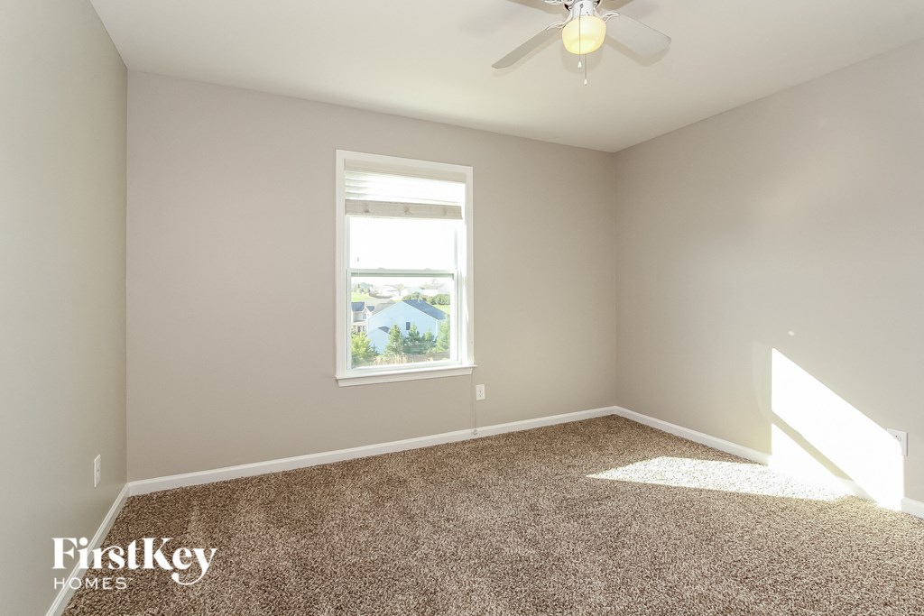 a bedroom with a ceiling fan and a window