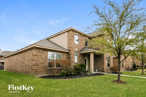 A brick house with a tree in front of it.