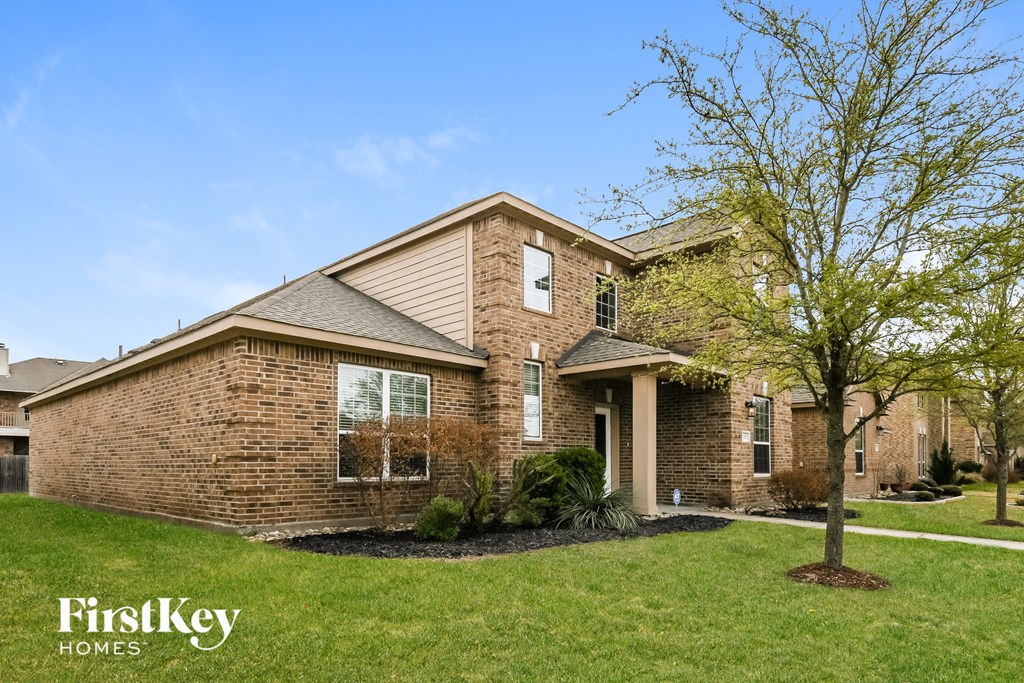 A brick house with a tree in front of it.