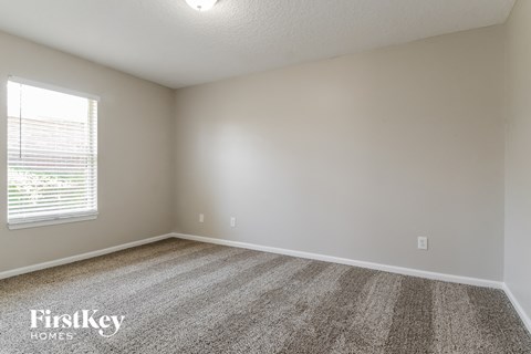 the upstairs bedroom with carpet and window