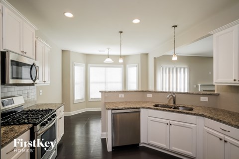 a kitchen with white cabinets and granite counter tops