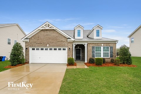 A house with a garage and a driveway in front of it.