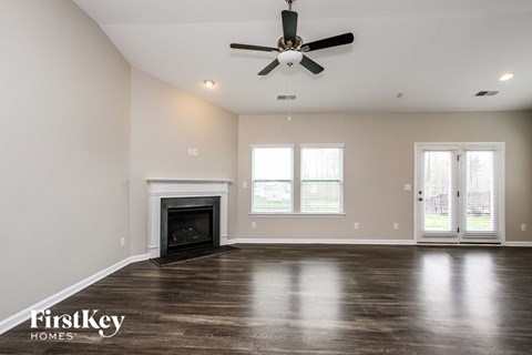 A spacious room with a fireplace and a ceiling fan.