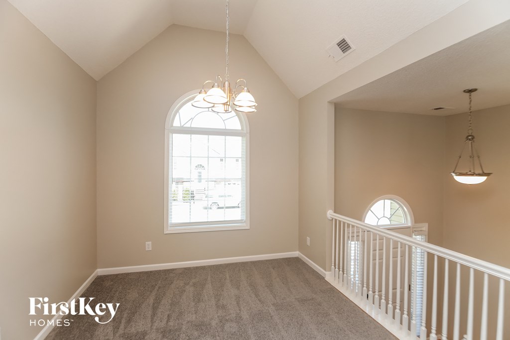 A room with a large window and a balcony railing.
