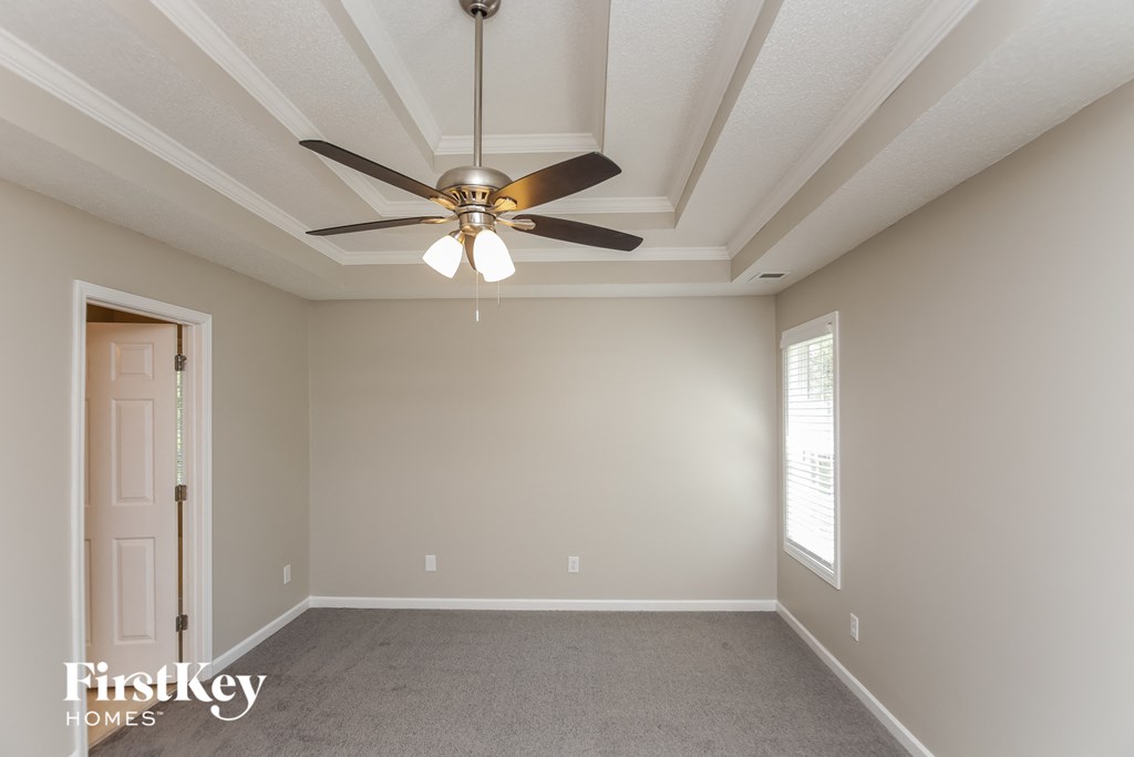 A room with a ceiling fan and a door.