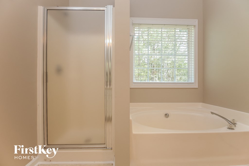 A bathroom with a tub and a window.