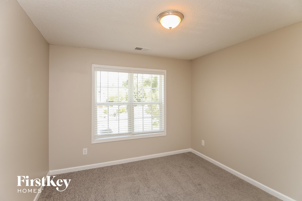 A room with a window and a car parked outside.
