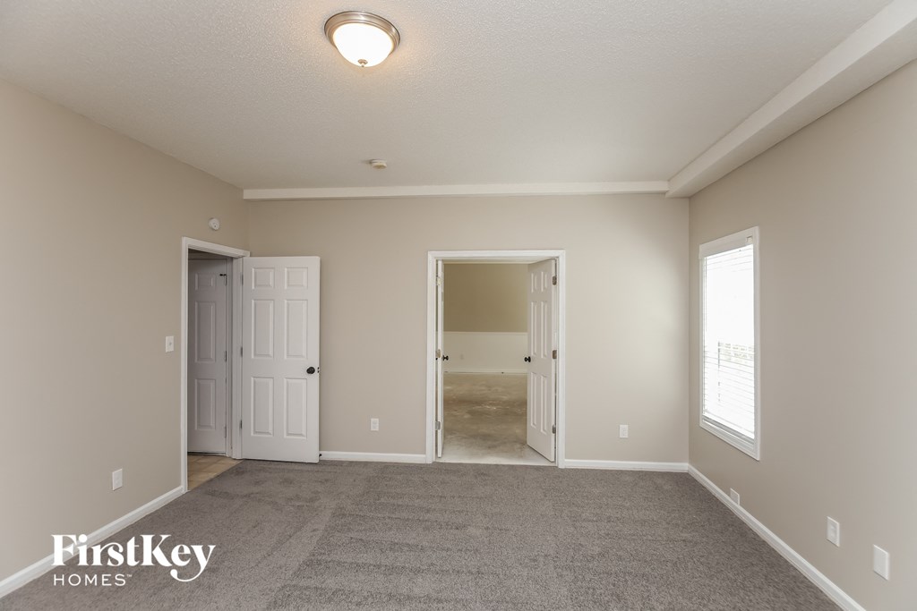 A spacious room with a carpeted floor and two doors.