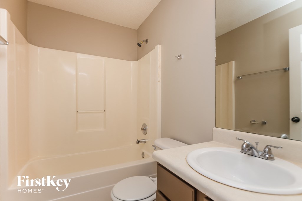 A bathroom with a white toilet, sink, and bathtub.