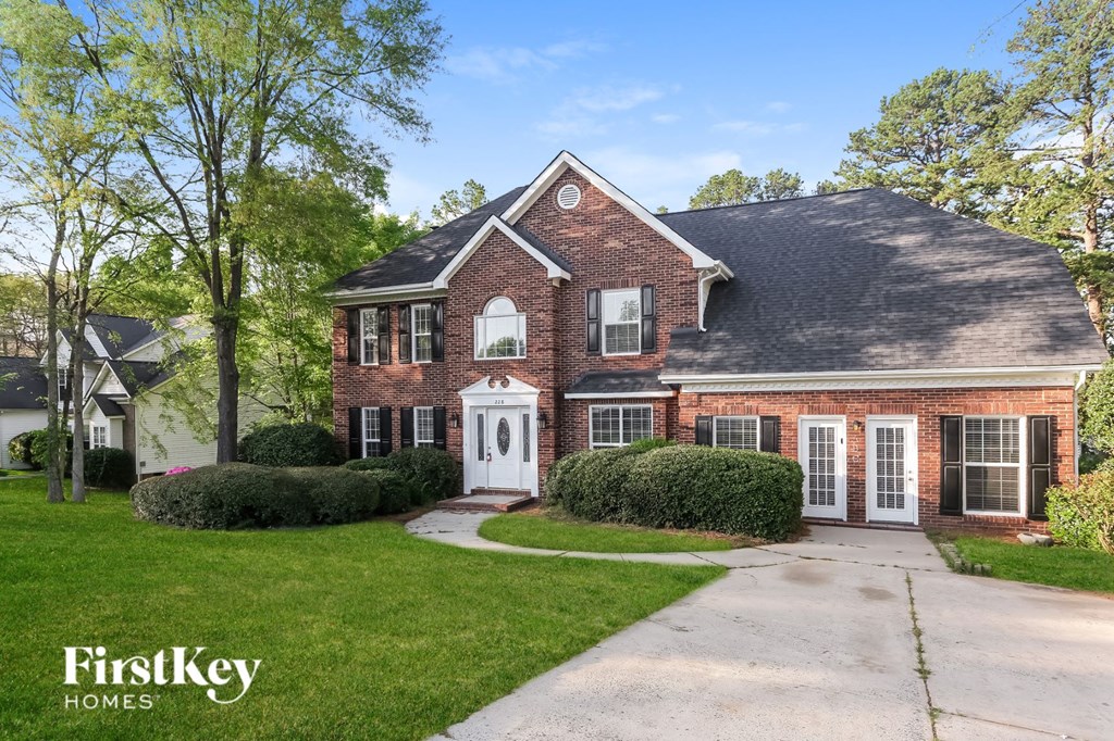 a brick house with a white front door and a driveway