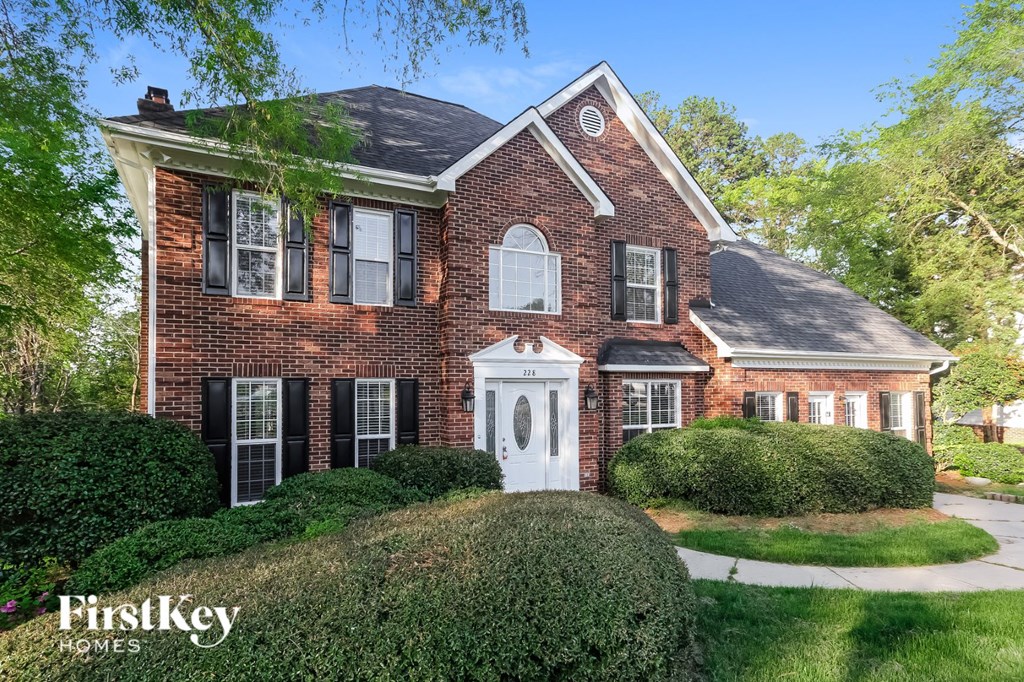 a brick house with a white front door and a lawn