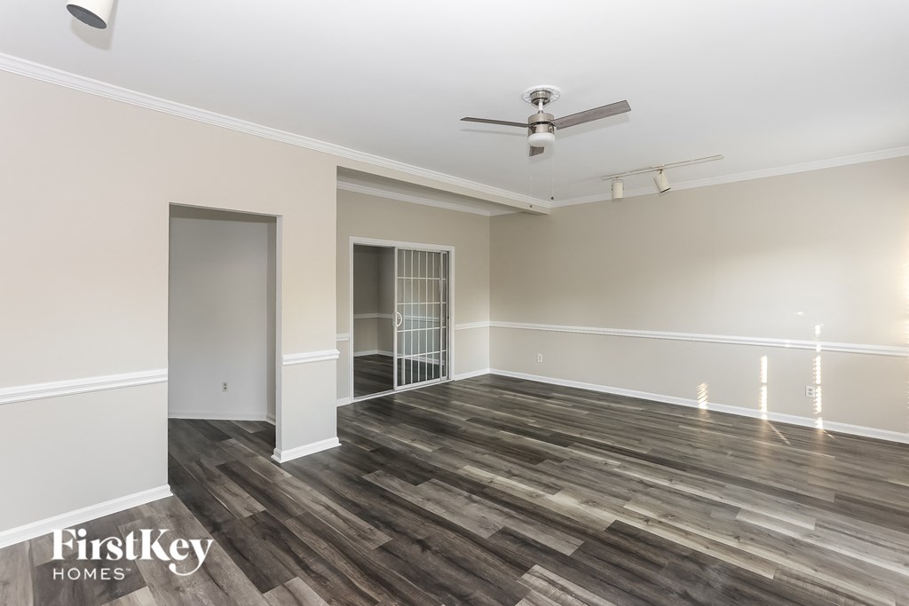 a living room with wood flooring and a ceiling fan